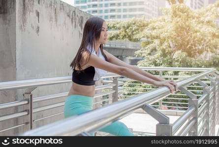 Asian healthy woman doing exercise and stretch outside. Sport and Lifestyle Concept.