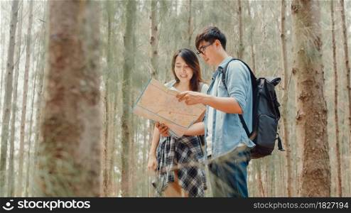 Asian hiker couple trekking in forest. Young happy backpack male and female walking enjoy her journey, travel nature and adventure trip, climb mountain lot of tree in fall holidays vacation concept.