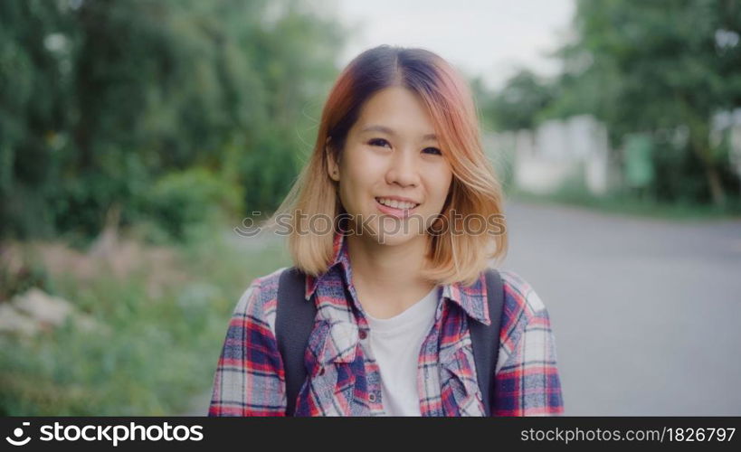 Asian hiker woman trekking in forest. Young happy backpack girl smiling to camera, travel nature and adventure trip, climb mountain lot of tree in spring holidays vacation concept.