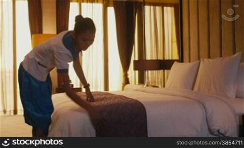 Asian housemaid cleaning hotel room, woman, people working. Girl in resort suite bedroom, setting up bed, staff, employee at work as housekeeper, professions, jobs. 1of5