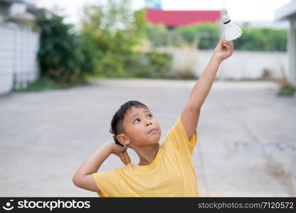 Asian kid boy playing badminton at home