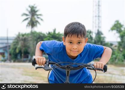asian kid boy ride bicycle in nature
