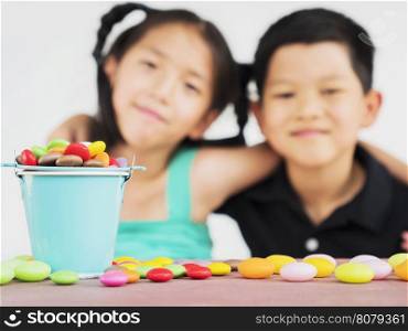 Asian kids are playing with candy. Photo is focused at candy.