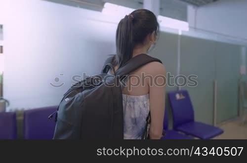 Asian lady wear face mask walk and sitting down on disinfected benches with social distancing sign, keep away distance, inside public building, relaxed comfortable new normal travel, on the move