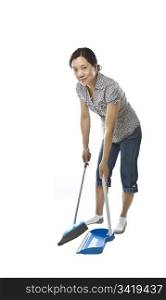 Asian lady with broom and dust pan while wearing causal clothing on white background