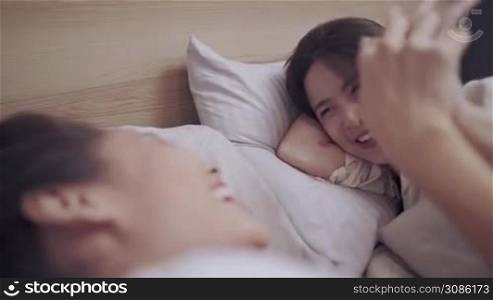 Asian lgbt lesbian couple lying on bed, holding hands playing with each other, LGBT freedom, bonding relationship, comfortable bedroom warm blanket, sexual equality sharing love, transgender movement