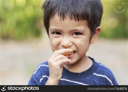 Asian little boy eating fish crisp