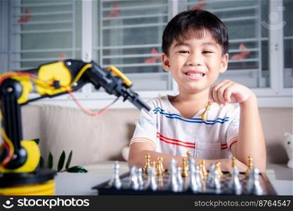 Asian little boy is playing chess with robot machine arm, STEM education E-learning, Funny children learning successful getting a lesson control robot arm, Technology science education concept