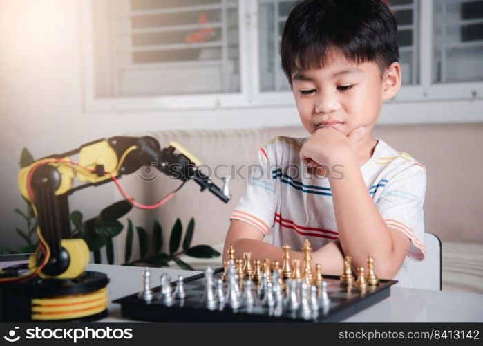 Asian little boy thinking and wait robot arm playing chess, STEM education E-learning, Funny children learning successful getting a lesson control robot arm game, Technology science education concept