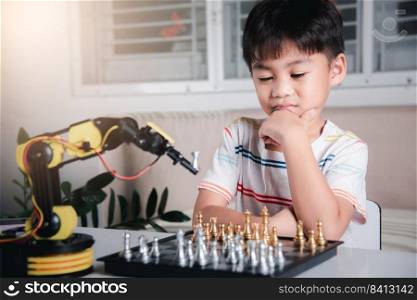 Asian little boy thinking and wait robot arm playing chess, STEM education E-learning, Funny children learning successful getting a lesson control robot arm game, Technology science education concept