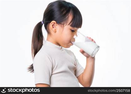 Asian little cute girl drinking milk from a glass on white background in studio. Healthy nutrition for small children.
