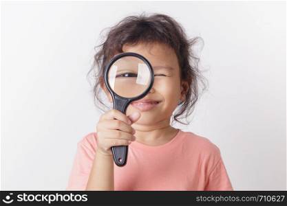 Asian little girl holding magnifying glass smiling. A Little cute child girl looking magnifying glass on white background.