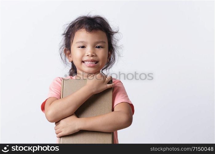 Asian little girl is hold a brown book and smiling while standing on white background