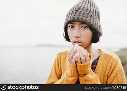 Asian little girl wearing wool hat on river blurred background in the winter morning