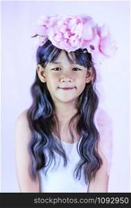 Asian little girl with black hair, dressed in a wreath of flowers on her head. Asian little girl with black hair