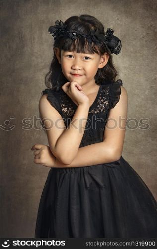 Asian little girl with black hair, dressed in a wreath of flowers on her head. Asian little girl with black dress