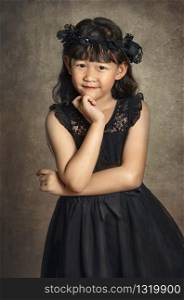 Asian little girl with black hair, dressed in a wreath of flowers on her head. Asian little girl with black dress