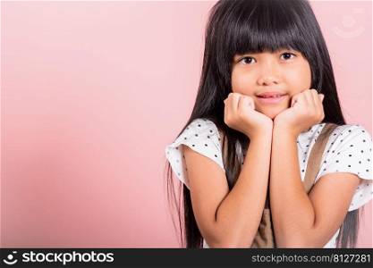 Asian little kid 10 years old hands touch chin thinking dream at studio shot isolated on pink background, Portrait of Happy child girl positive smiling rejoices good day with lover