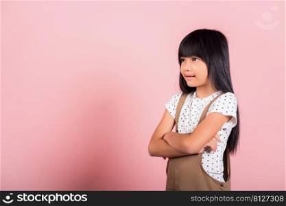 Asian little kid 10 years old smiling with arms crossed at studio shot isolated on pink background, Portrait of Happy confidence child girl lifestyle, Positive person