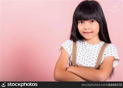 Asian little kid 10 years old smiling with arms crossed at studio shot isolated on pink background, Portrait of Happy confidence child girl lifestyle, Positive person