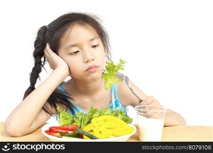 Asian lovely girl showing boring expression with fresh colorful vegetables and glass of milk isolated over white background