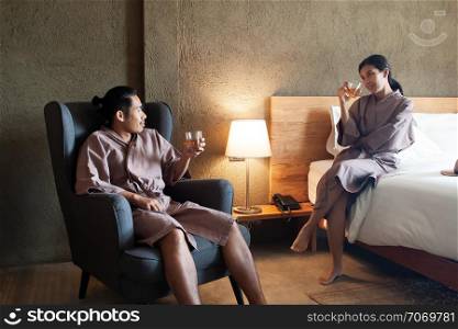 Asian lover drinking whisky together in bedroom. Lifestyle or love concept