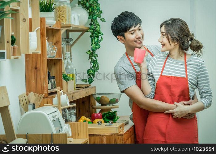 Asian Lover or Couple cooking and Tasting food in the kitchen room at the modern house, Couple and life style concept.