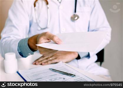 Asian male doctor handing giving a prescription to the patient.