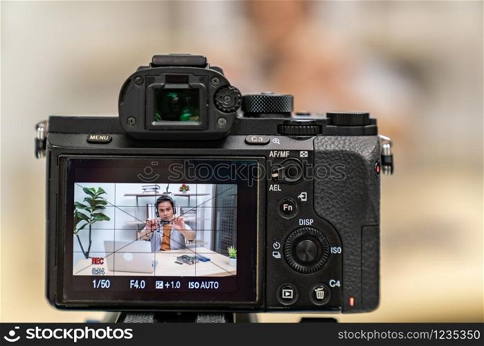 asian male IT vlogger and blogger live Technology upgrand on laptop memory ram using digital camera recording live vlog video. Online influcencer on social media concept. Focus on camera.