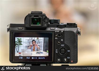 asian male IT vlogger and blogger live Technology upgrand on laptop memory ram using digital camera recording live vlog video. Online influcencer on social media concept. Focus on camera.