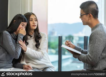 Asian male professional psychologist doctor giving the consult to Lesbian lovers patients which have relationship problem in modern living room of house or hospital exam room, Mental health Concept