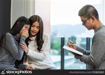 Asian male professional psychologist doctor giving the consult to Lesbian lovers patients which have relationship problem in modern living room of house or hospital exam room, Mental health Concept