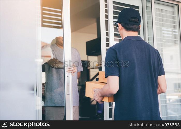 Asian man accepting delivery from a male courier at in front of home.