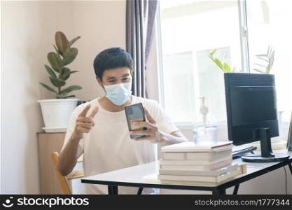 Asian man administrator staff call center in home service office assistance work from home looking data customer from computer communication during coronavirus covid-19