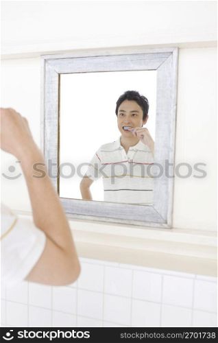 Asian man brushing his teeth