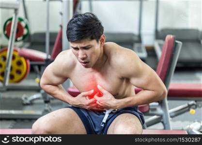 Asian man chest pain after workout in gym,Healthcare and medical Concept