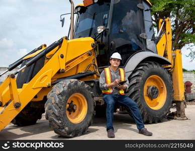 Asian man civil construction engineer worker or architect with helmet and safety vest working and holding a paper board note for see blueprints or plan at a building or construction site. Man construction engineer at construction site