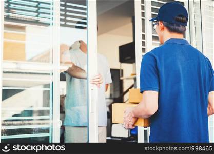 Asian man Delivery service with boxes in hands standing in front of Customer's house doors