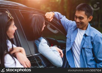 Asian man flirting women in car during travel in forest. Boy talking to girls for meeting. People lifestyles and weekend tour concept. Summer and nature theme. Mountain camping people group in holiday