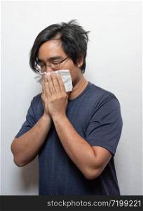 Asian man getting cold or flu,he is coughing to clear throat with hand holding tissue paper closing his mouth isolated on white background Illness and sickness concept.