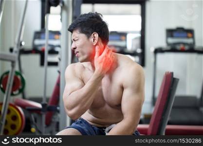 Asian man have injury muscle in a neck pain after workout in gym,Healthcare concept