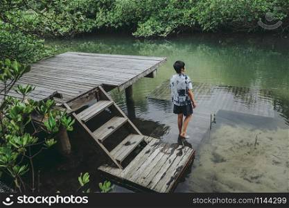Asian man in Beautiful mangrove forest Lagoon vacation time