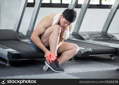 Asian man injury ankle pain after training running workout in gym feeling so pain,Healthcare Concept