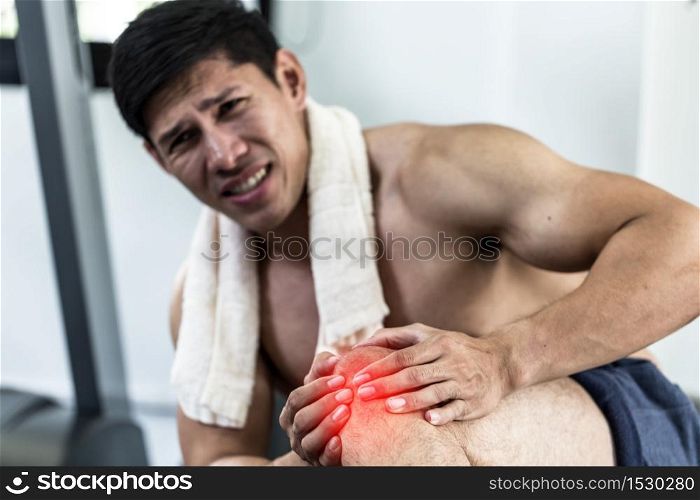 Asian man injury kneecap pain after training running workout in gym feeling so pain,Healthcare Concept