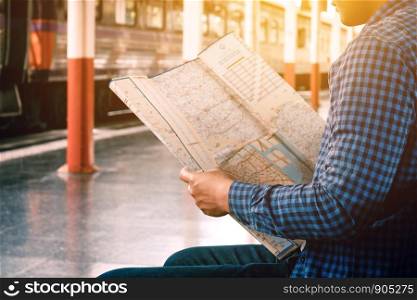 Asian man looking map with finding location for travel.