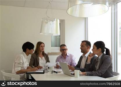 Asian man participating in a business meeting with caucasian colleagues in beautiful bright and cozy environment, might be a startup company