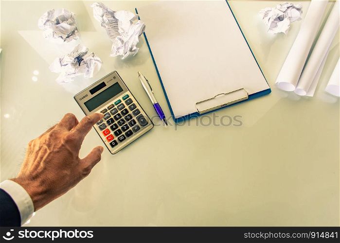 Asian man pressing calculator for business finance on desk office whitebackground.Metaphor for Success finance Dealing buying or accountantand earnings image