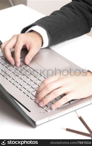 Asian man&rsquo;s hands typing on laptop keyboard
