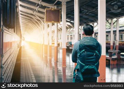 Asian man standing at platform train station waiting and looking future concept.