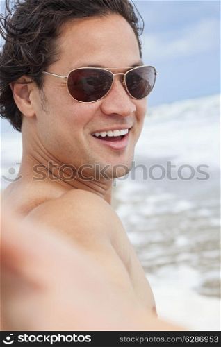 Asian man taking vacation selfie photograph at the beach